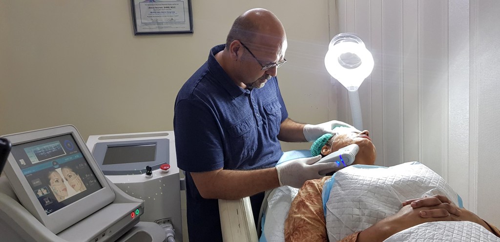 Dr. M. Khawar Nazir, an American-trained skin specialist, providing advanced skin treatment to a patient at Boston Aesthetics in Lahore.