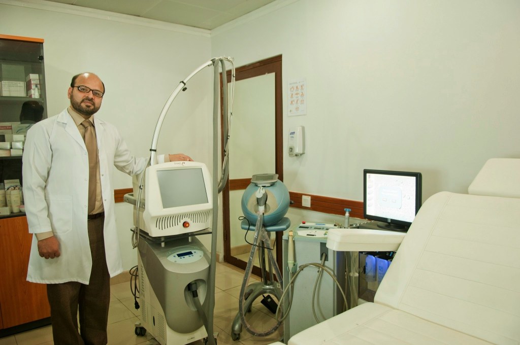 "Dr. M. Khawar Nazir, an American-trained dermatologist, stands beside advanced laser equipment in a treatment room at Boston Aesthetics Lahore, exemplifying the clinic's commitment to cutting-edge skincare solutions.