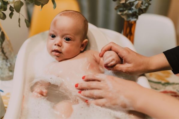 A baby taking a gentle bath with mild, fragrance-free cleanser in lukewarm water. Ideal for eczema-prone skin to maintain moisture and prevent irritation.